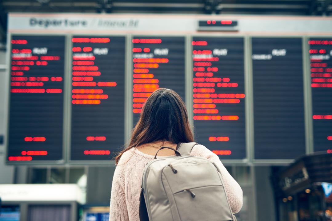 Female passenger looking up at a station board