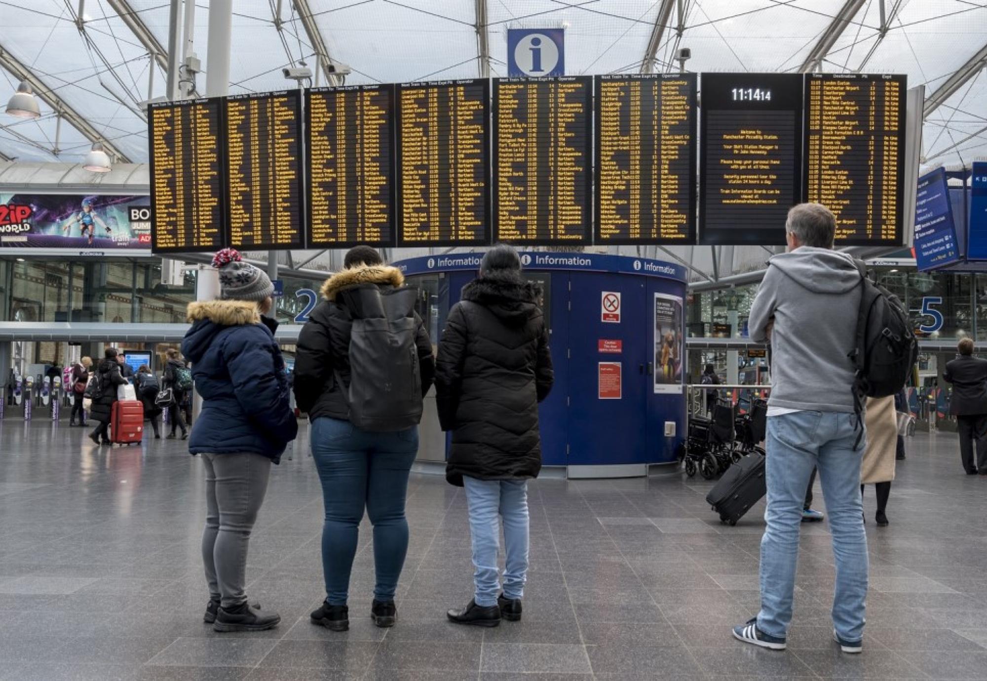 passengers looking at info board 