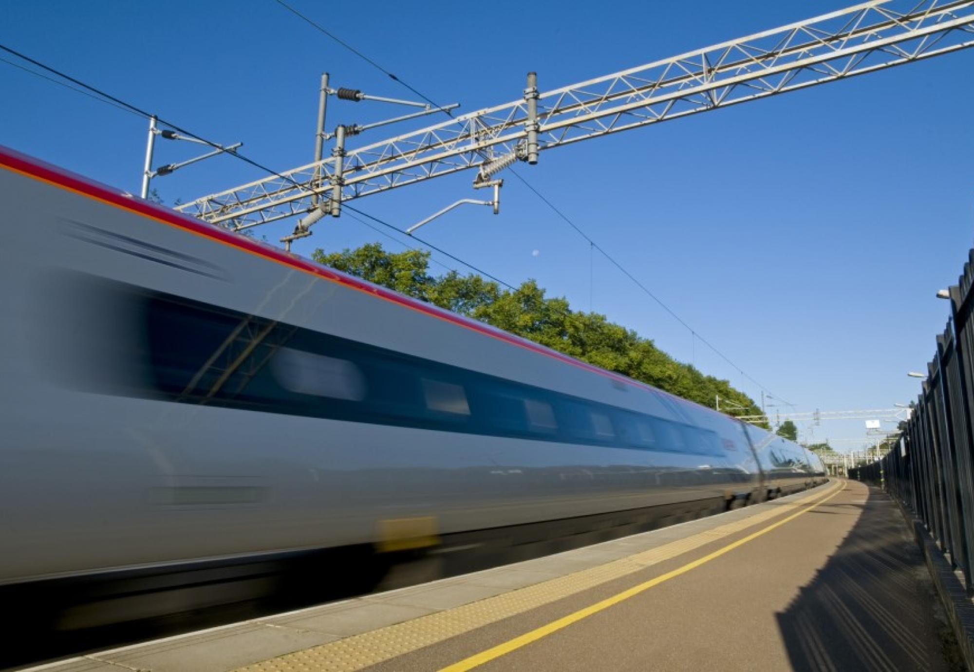 A British high speed passenger train passing through a station in the early morning