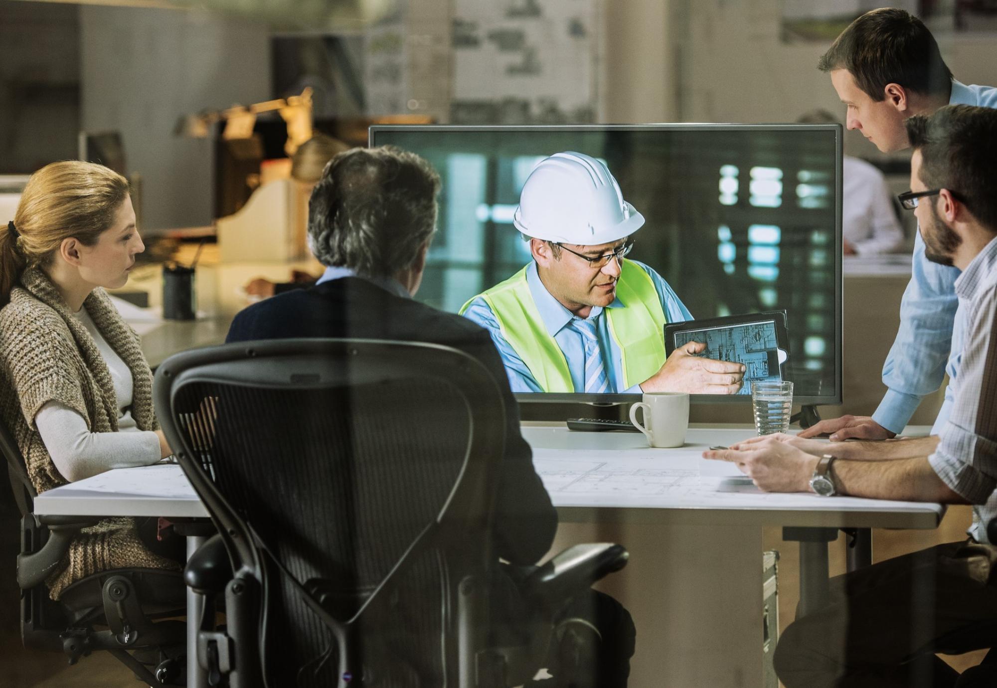 On site engineer discussing with academics in a meeting room