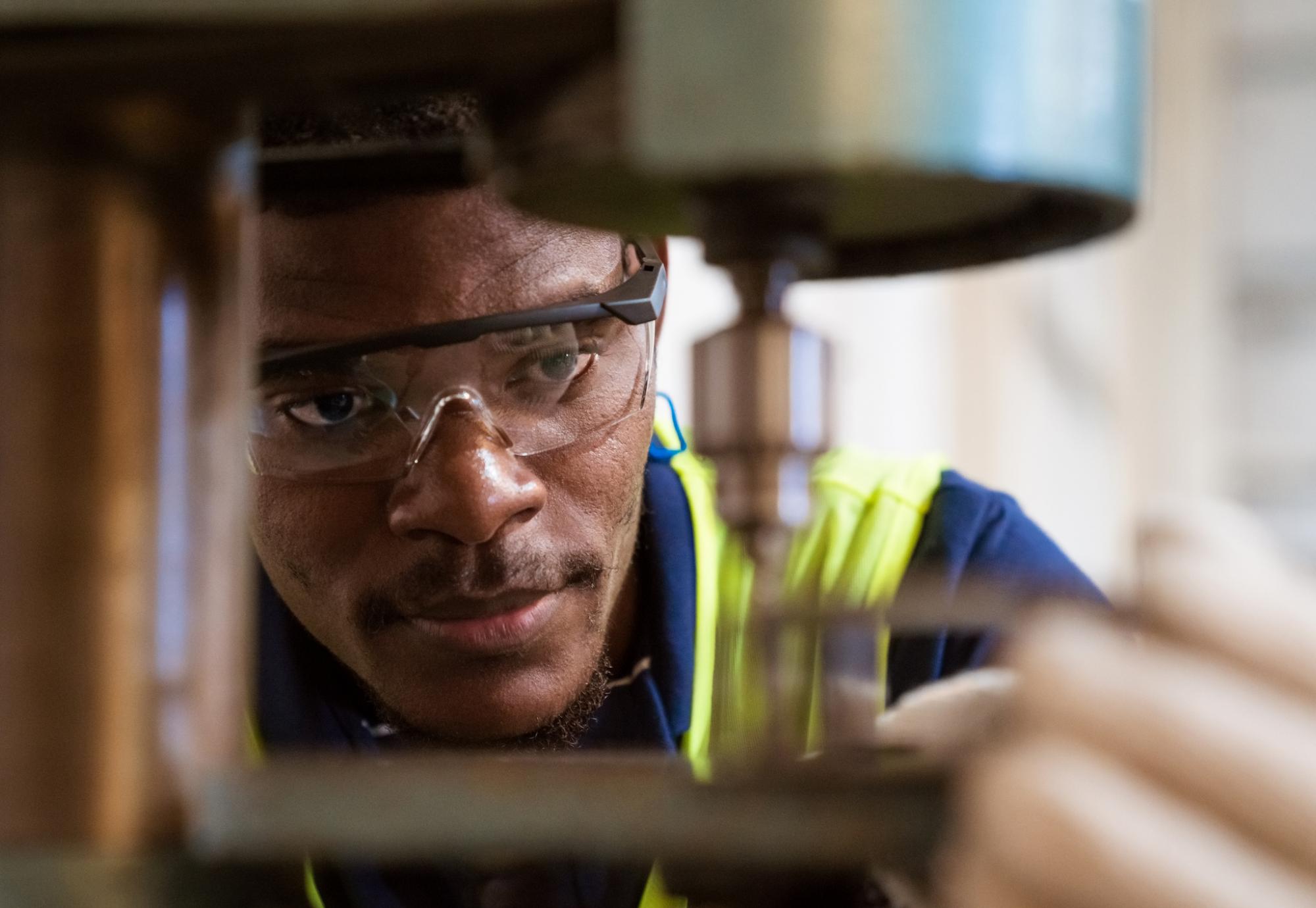 Engineer looking closely at a tool he is operating