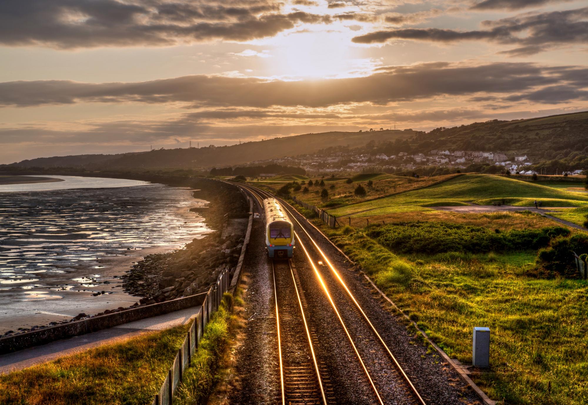 Train travelling through the countryside at sunset in Wales