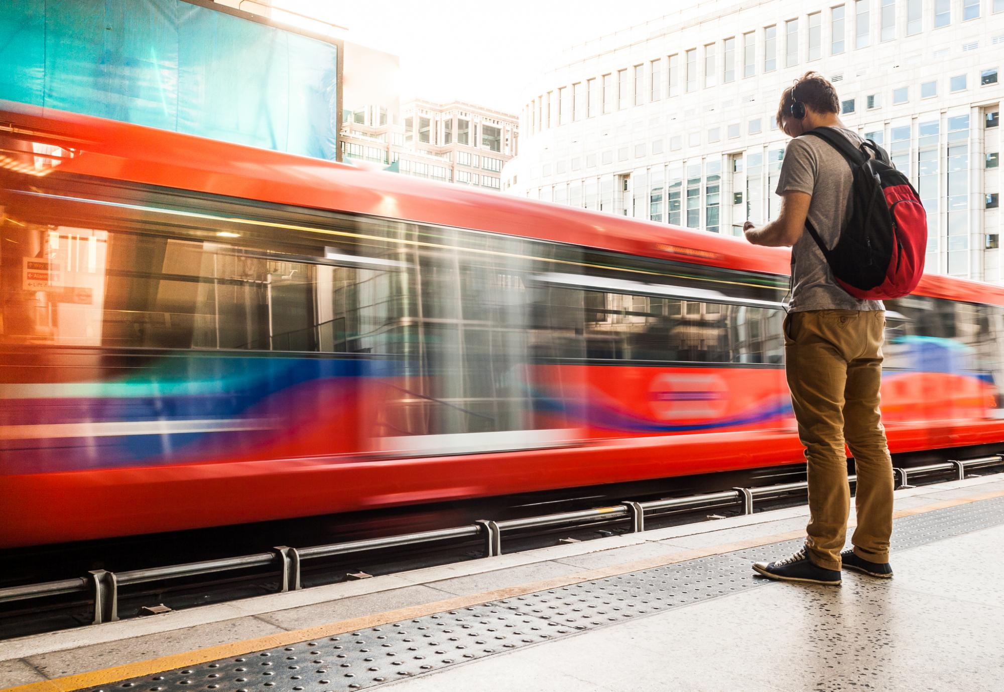 Man stood at a station platform as a train passes