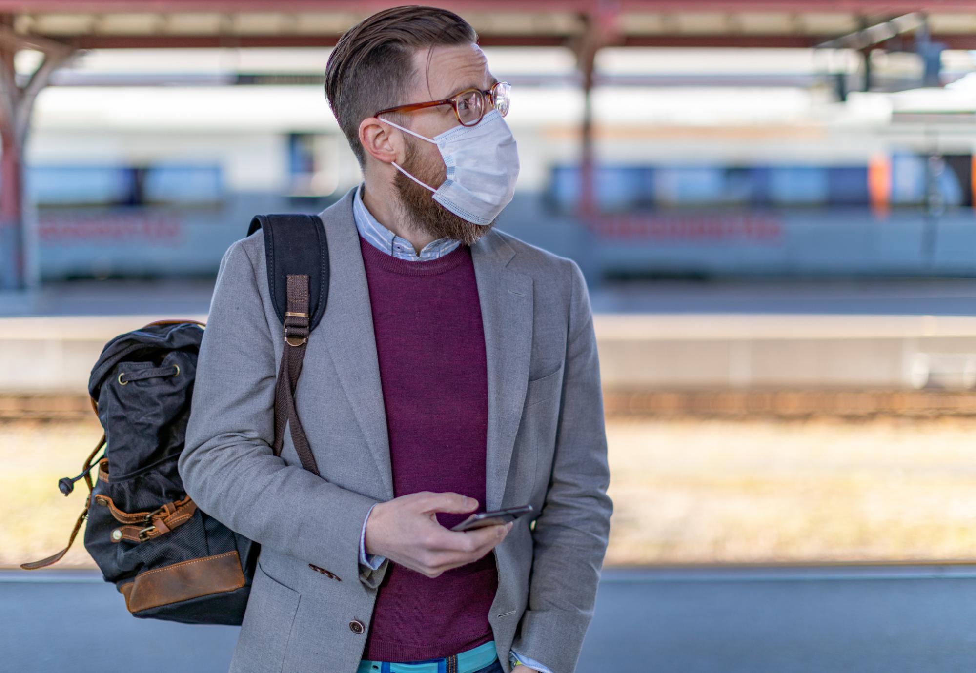 Passenger at a train station with phone