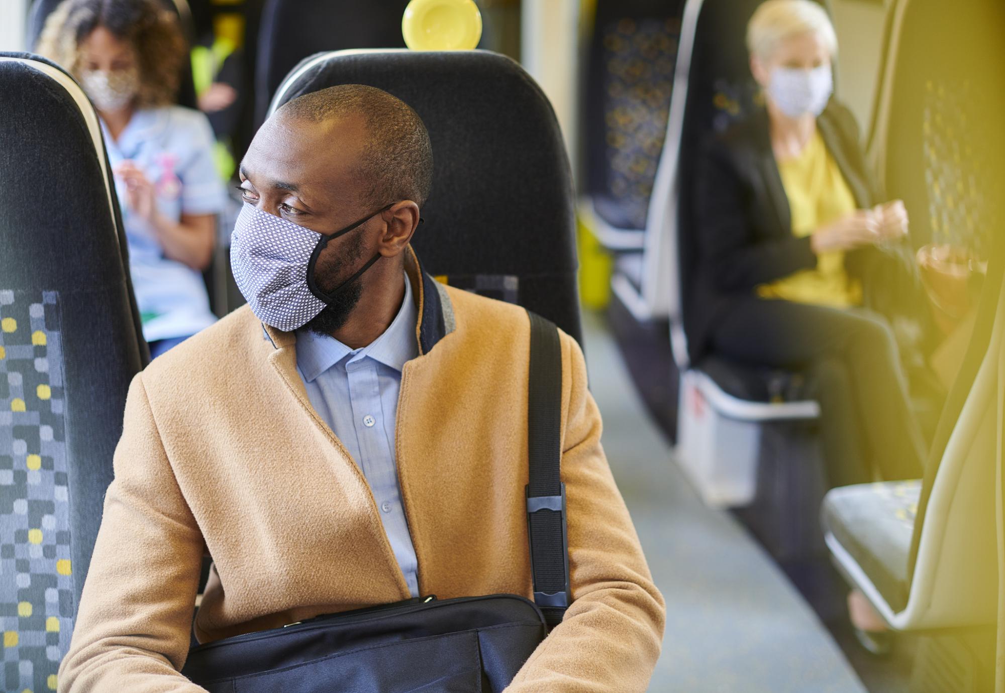 Train passenger sat in a seat wearing a face mask