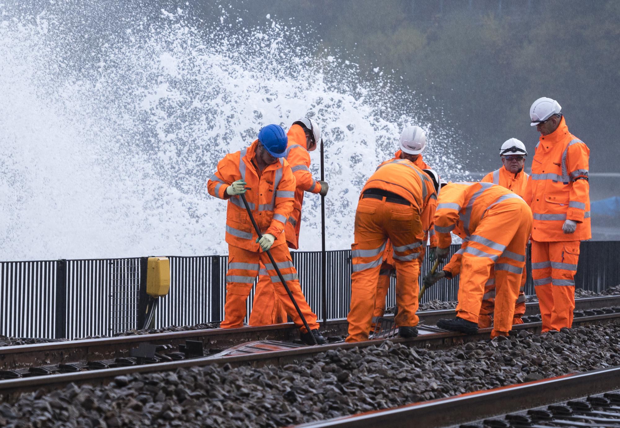 Rail workers perform work on tracks