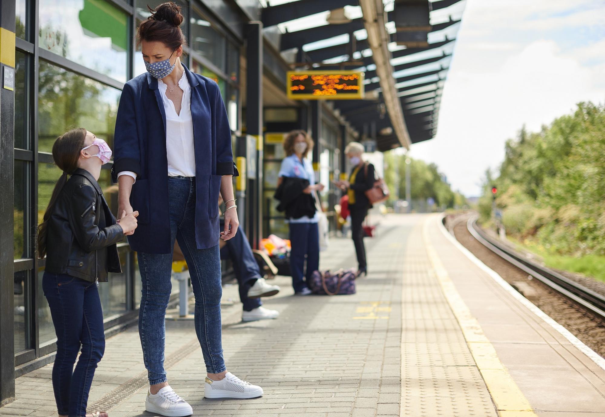 Mother and young daughter at a train platform