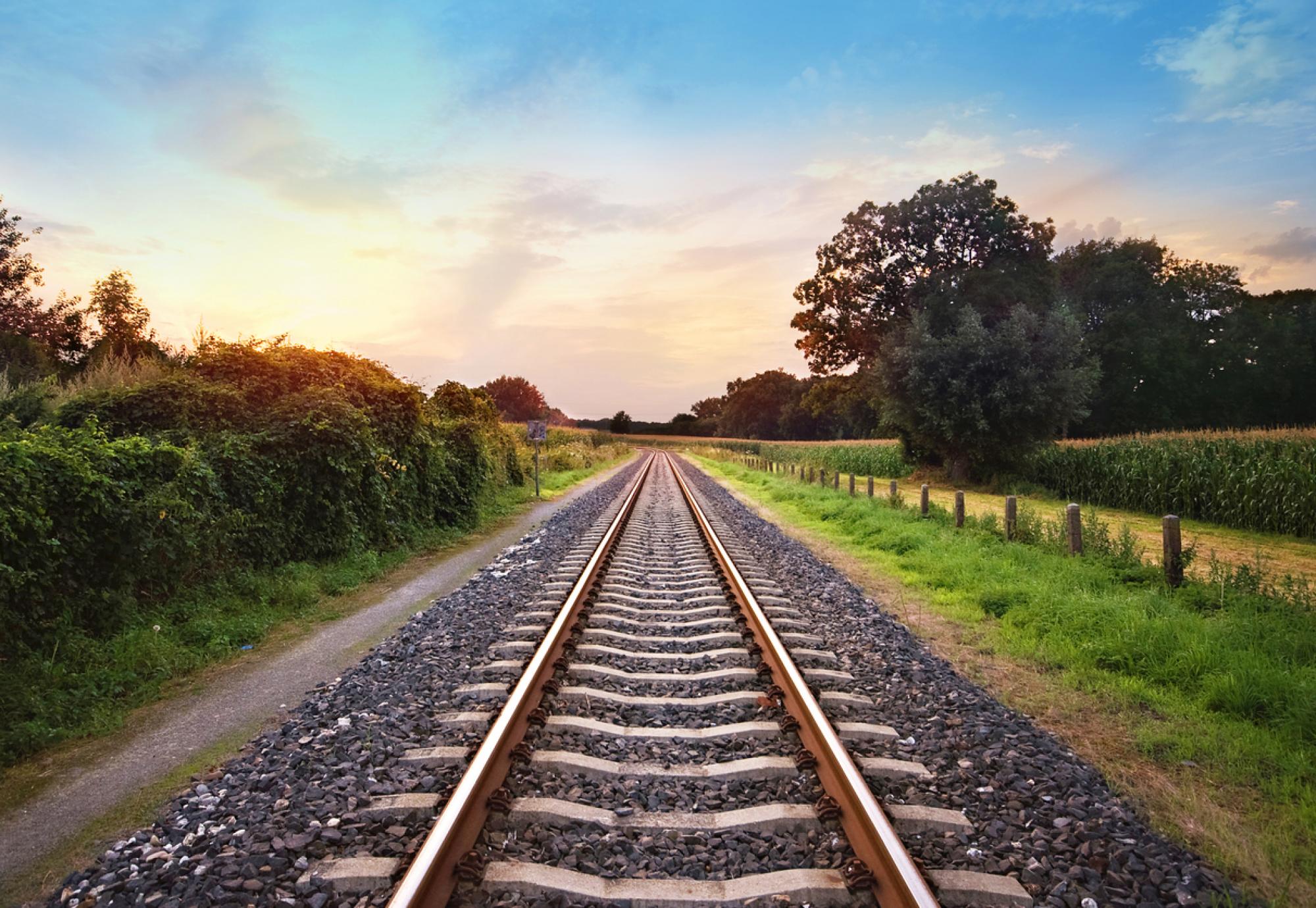 railway tracks in a rural scene with nice pastel sunset, via Istock 