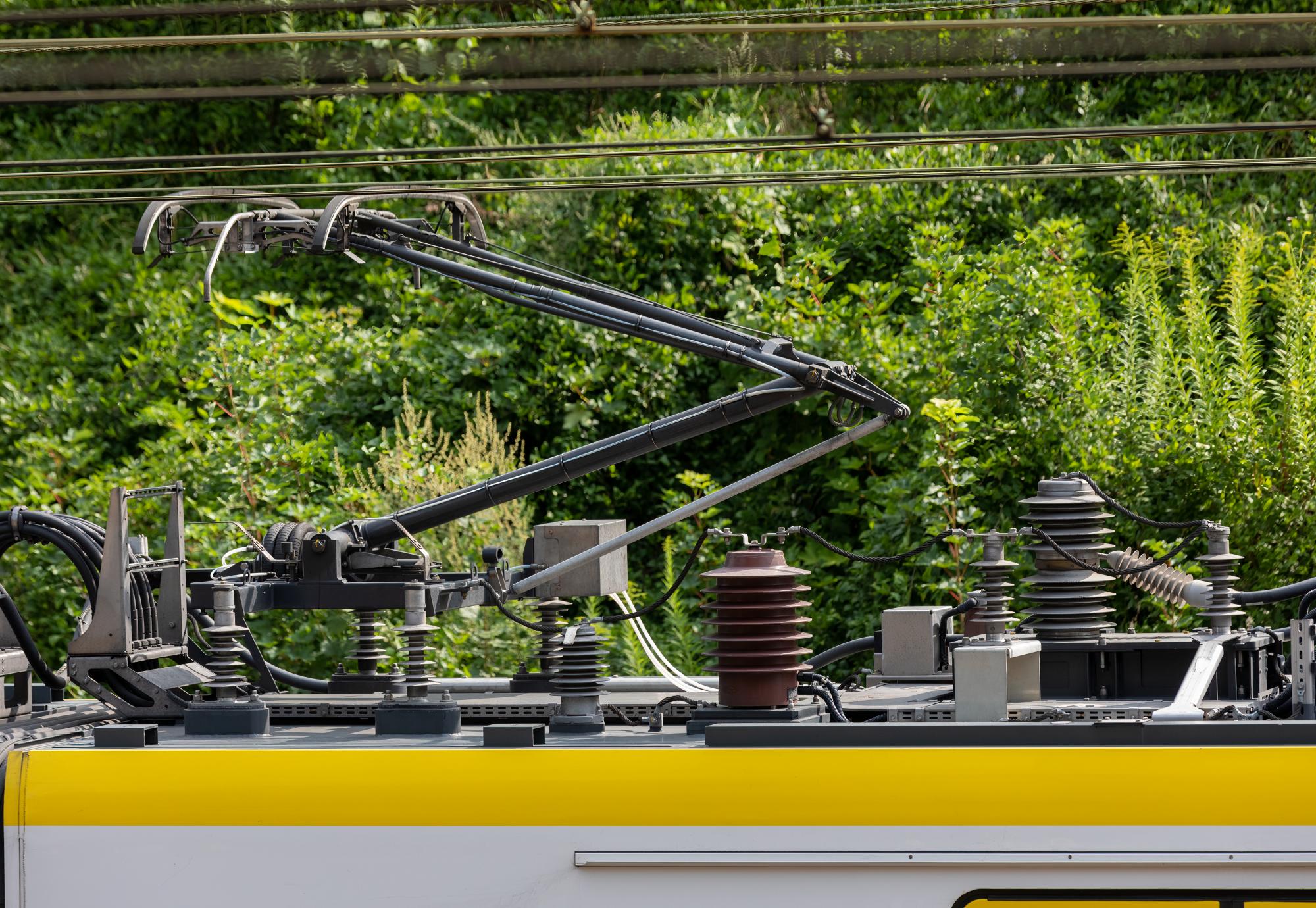 Electric train trolley pole, railway electrification system, overhead rig to supply energy for electric vehicle, via Istock 