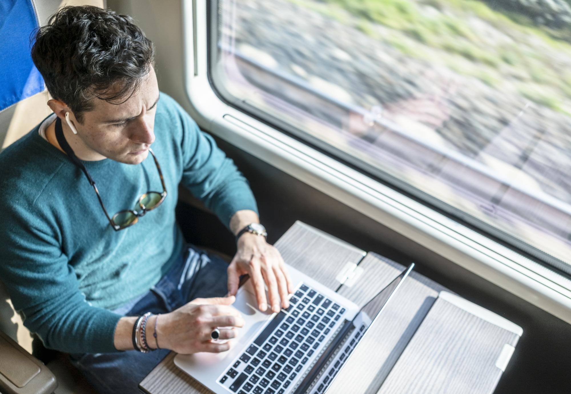 Man utilising internet connectivity on the train, via Istock 