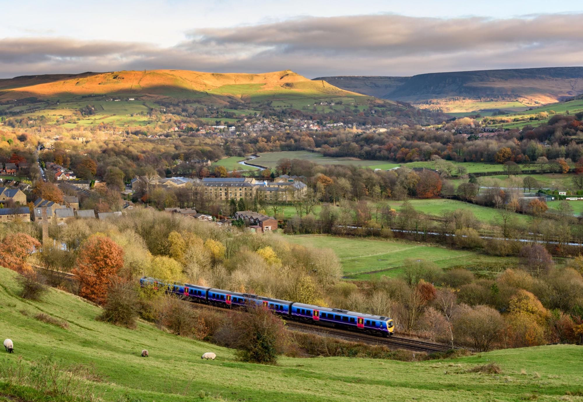 Passanger train passing through british countryside near greater Manchester, England.