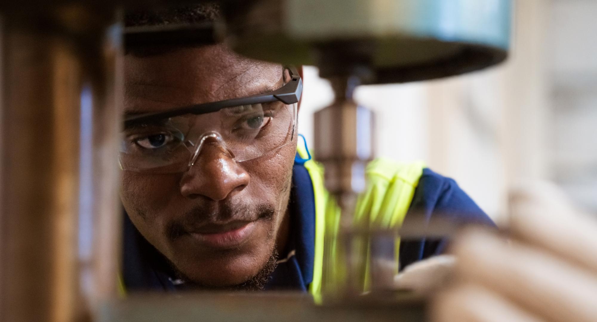 Engineer looking closely at a tool he is operating