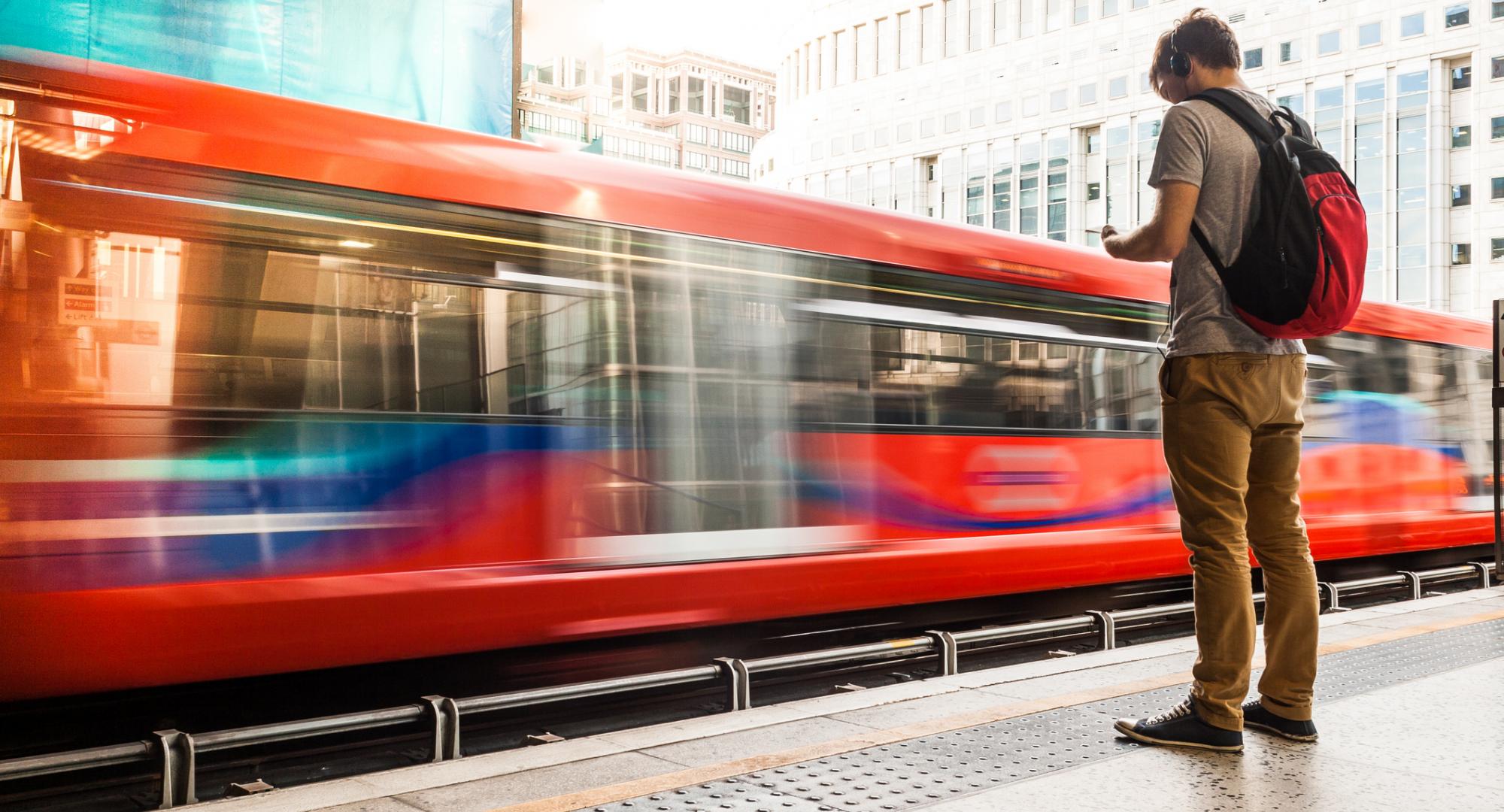 Man stood at a station platform as a train passes