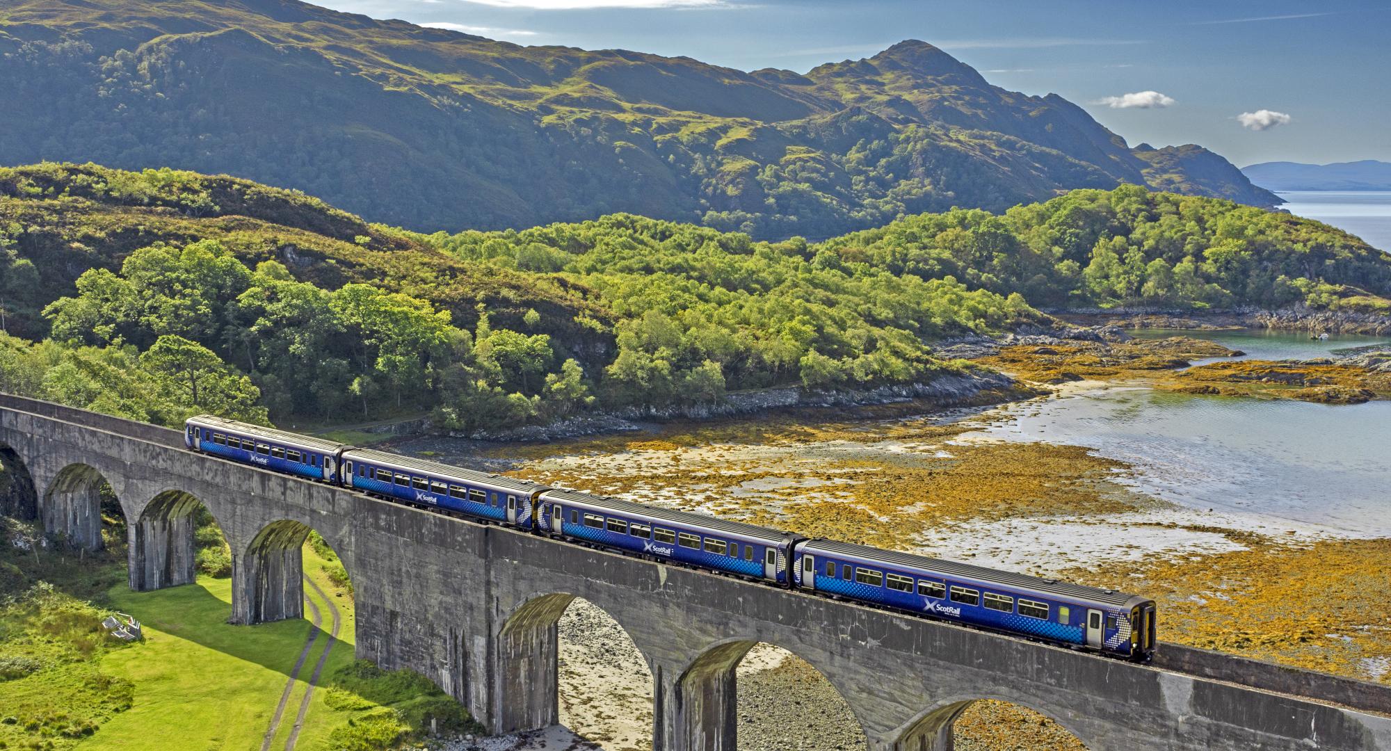 Scotrail train passing over the eight arch Nan Uamh Viaduct in late summer, via Istock