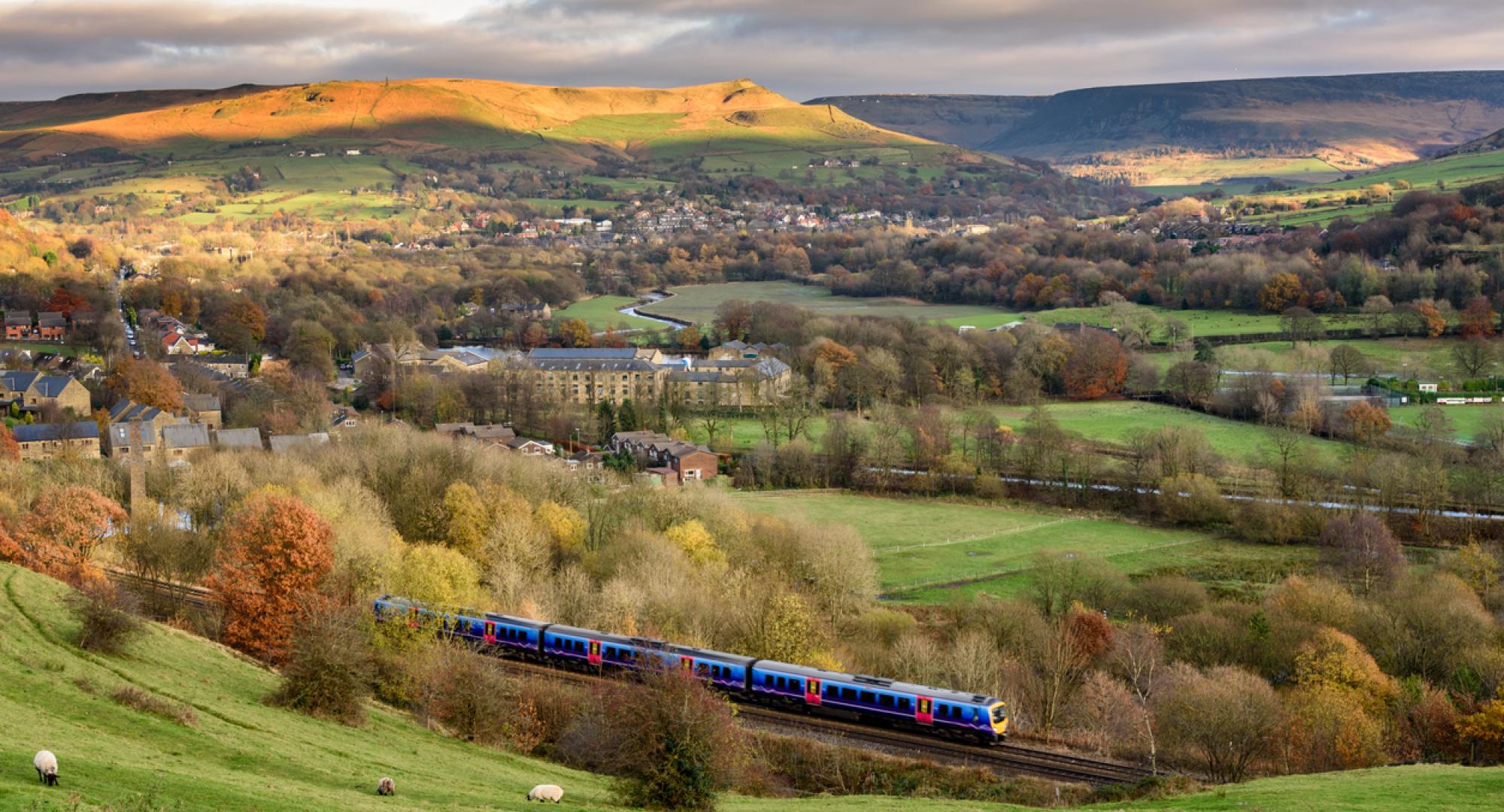 Passanger train passing through british countryside near greater Manchester, England.
