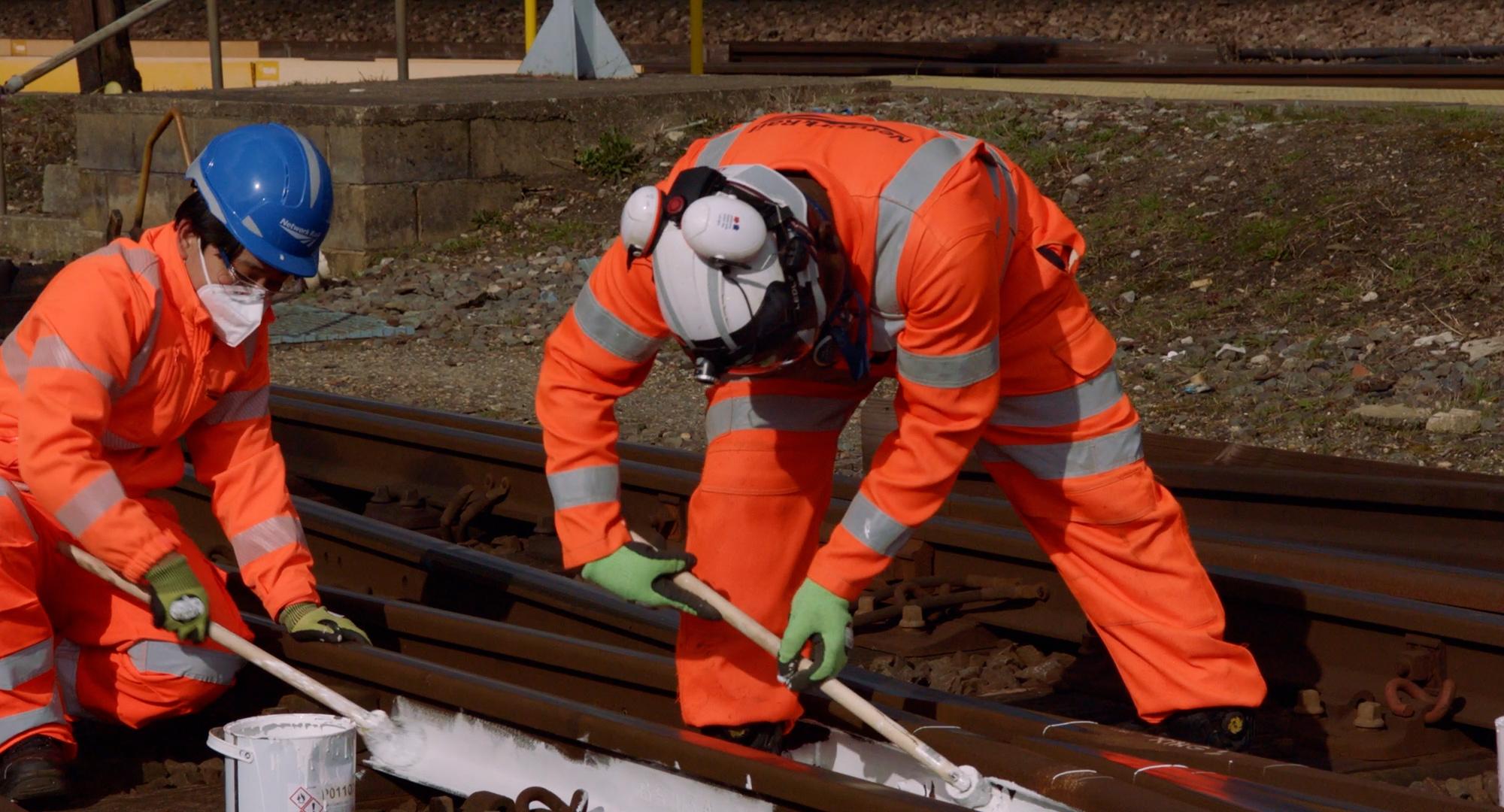 Rail workers painting the lines