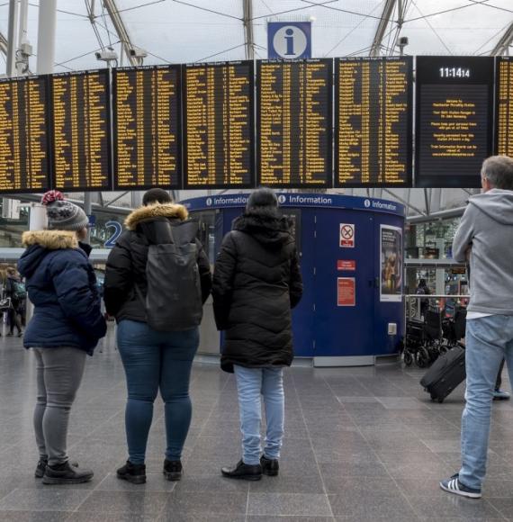 passengers looking at info board 