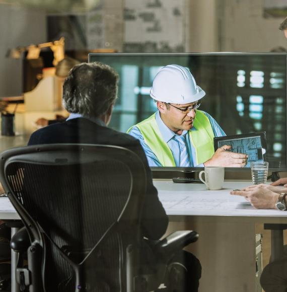 On site engineer discussing with academics in a meeting room