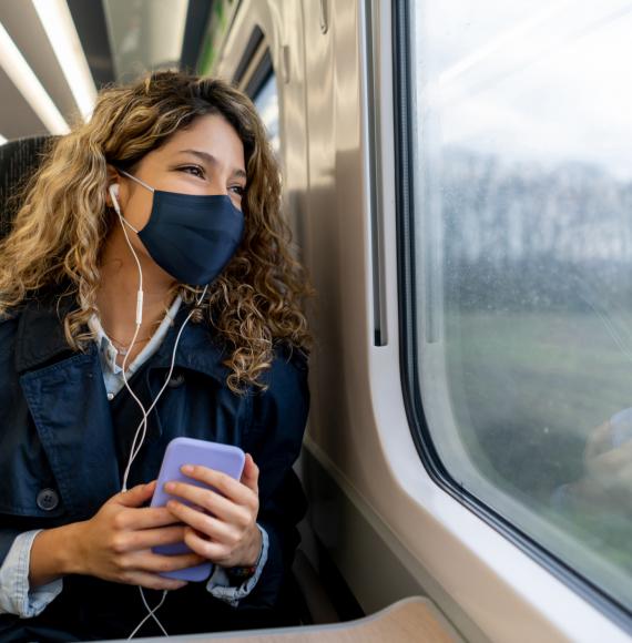 Woman wearing a face mask travelling on a train