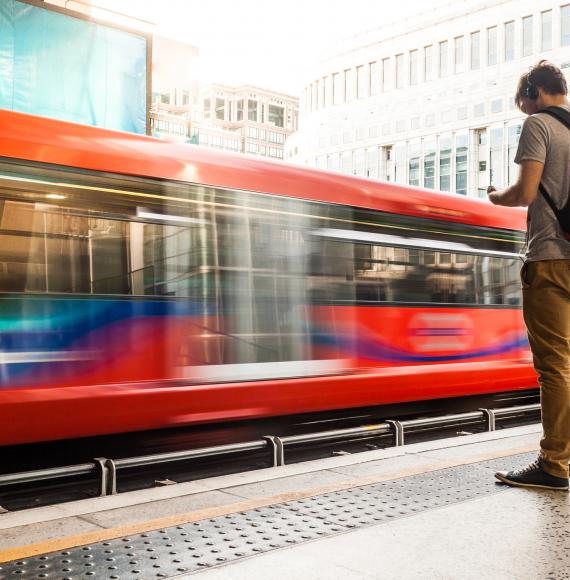 Man stood at a station platform as a train passes