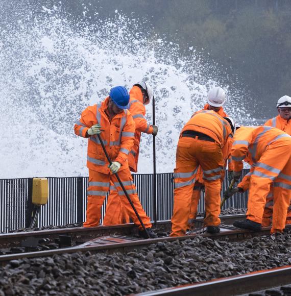 Rail workers perform work on tracks