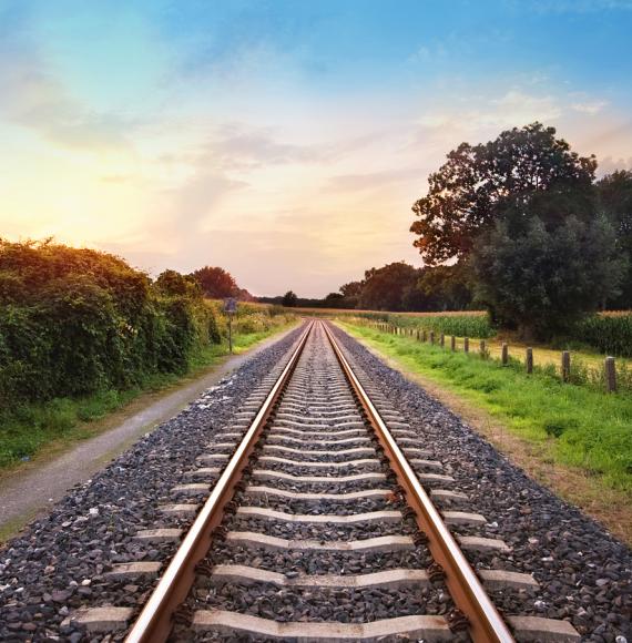 railway tracks in a rural scene with nice pastel sunset, via Istock 