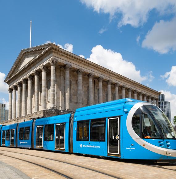 A blue West Midlands Metro tram at in front of Town Hall in Victoria Square, Birmingham, England, UK. Via Istock 