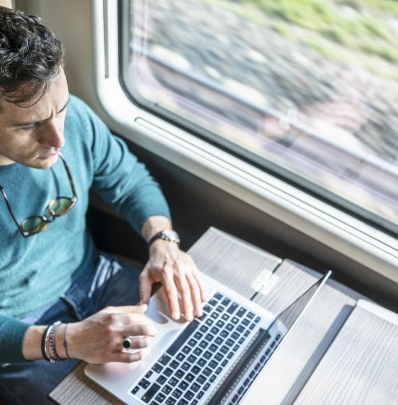 Man utilising internet connectivity on the train, via Istock 