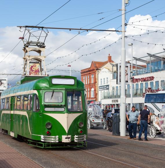 A green heritage tram on the promenade in Blackpool