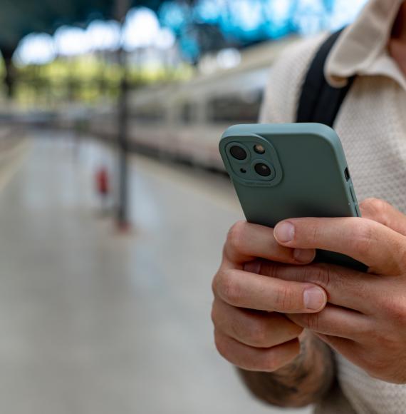 Man using a smart phone at a railway station