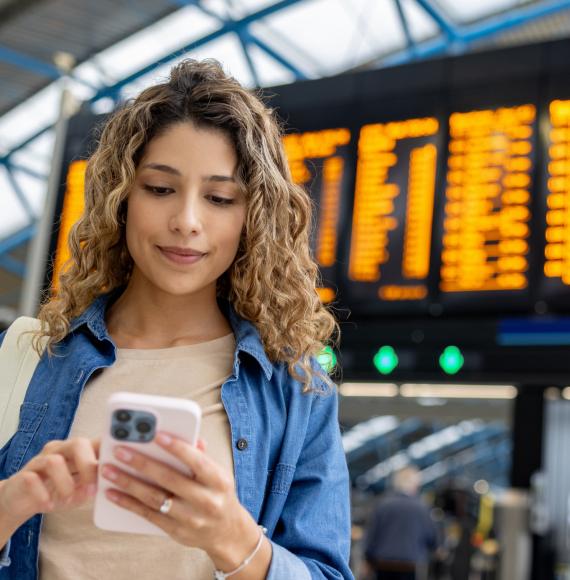 Portrait of a woman at the train station using her phone